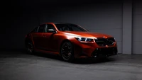 2025 BMW M5 : Élégante berline sportive orange dans une faible lumière