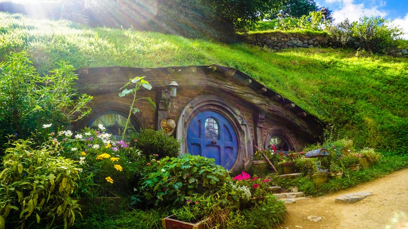 Близкий план дома хоббита с синей дверью и зеленой крышей (hobbiton movie set, новая зеландия, new zealand, властелин колец, the lord of the rings)