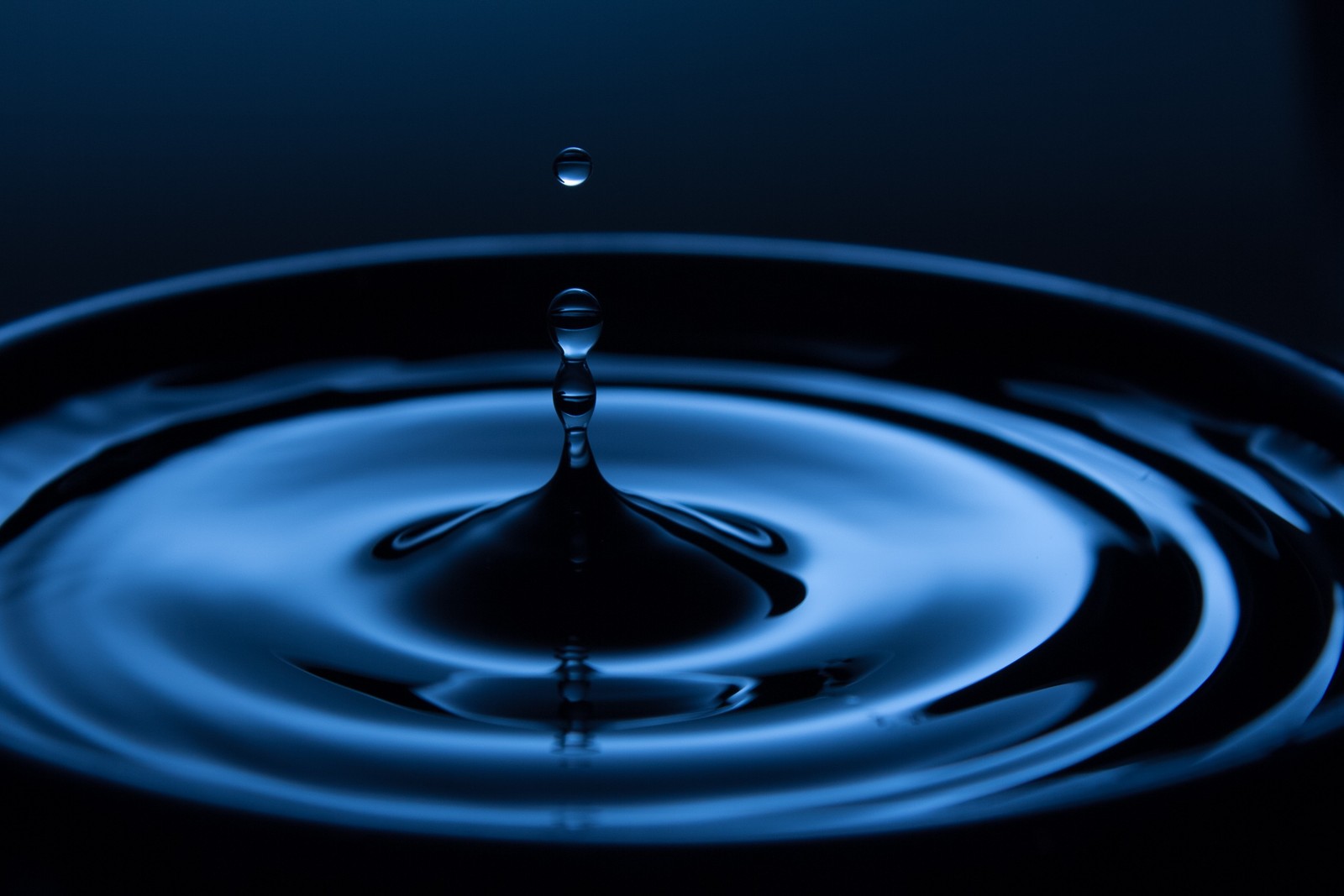 A close up of a water drop in a bowl with a blue background (water, drop, blue, liquid, water resources)