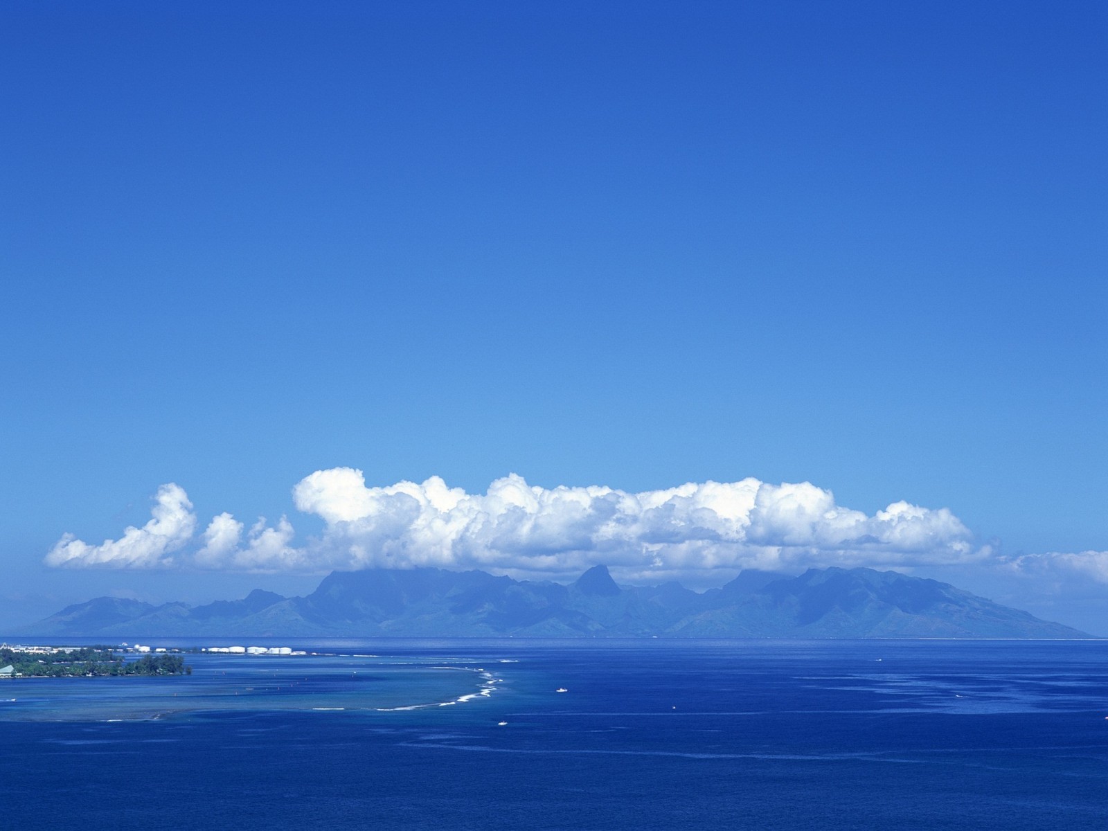 Vue aérienne d'un grand plan d'eau avec une montagne au loin (nuage, mer, océan, horizon, journée)