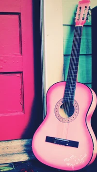 Guitarra rosa vibrante contra una puerta colorida