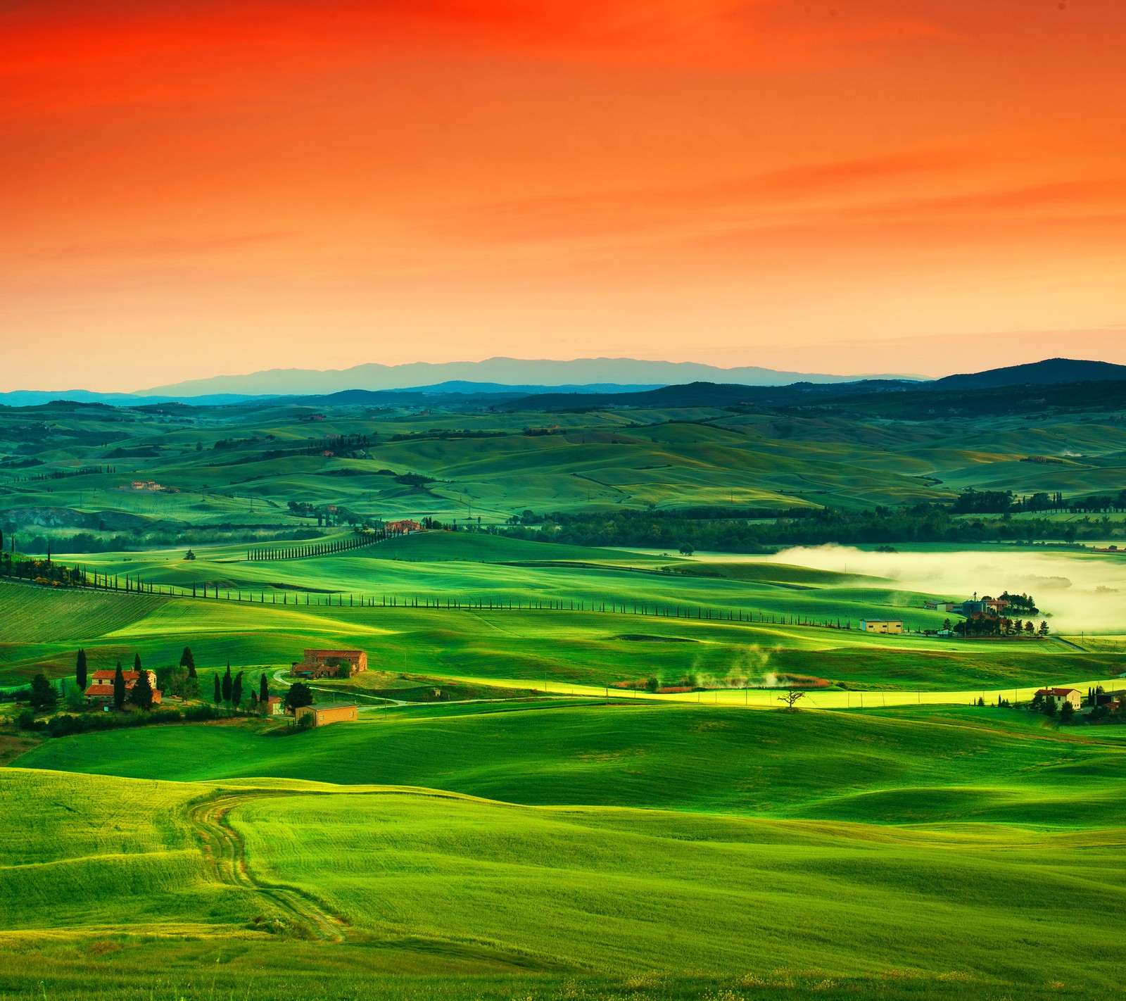 A view of a green field with a lake and mountains in the distance (beautiful colorful, landscape, nature)