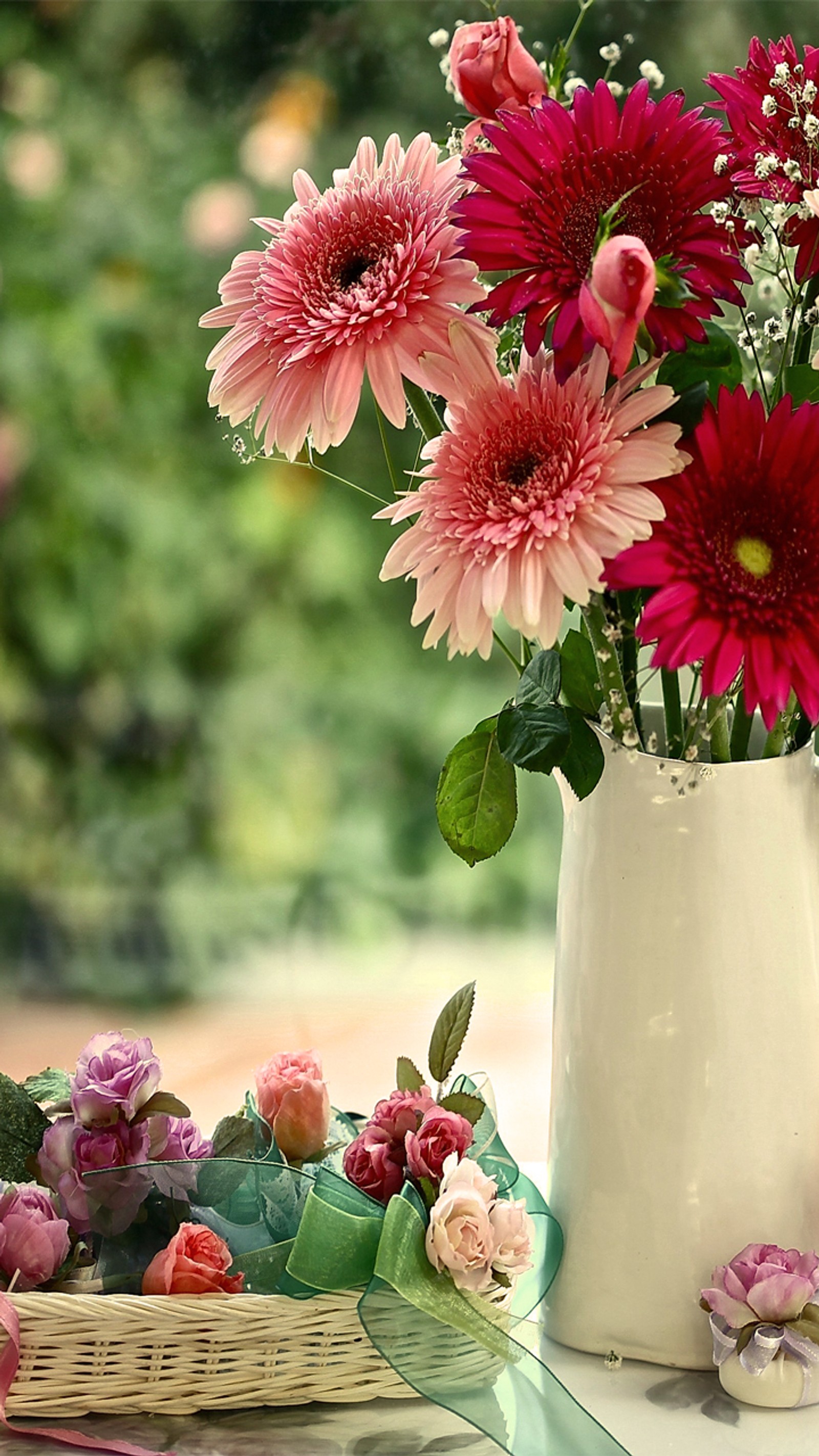 There is a white vase with pink and red flowers in it (flower, nature)