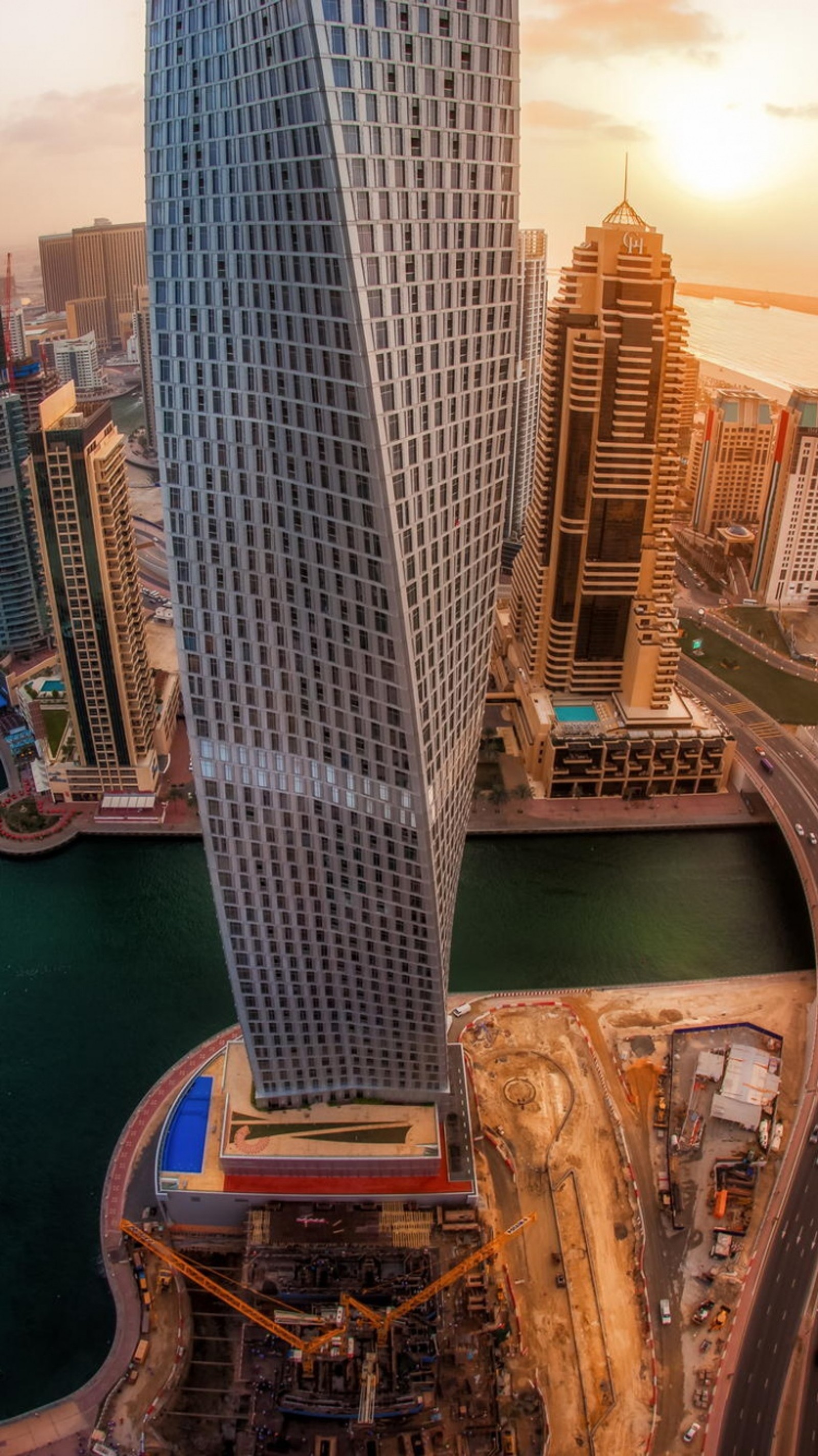 Uma vista panorâmica de uma cidade com um grande edifício e um rio (cidade, dubai, arranha céus)