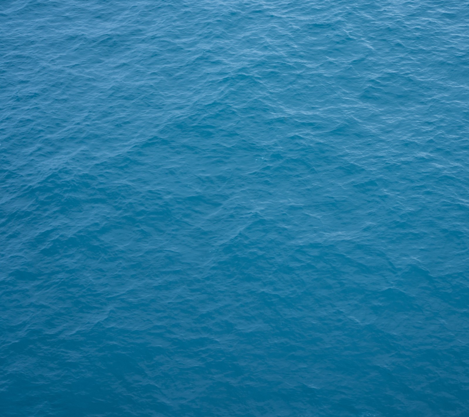 Vista aérea de un barco en el océano con un pequeño barco en el agua (fondo, azul, océano)