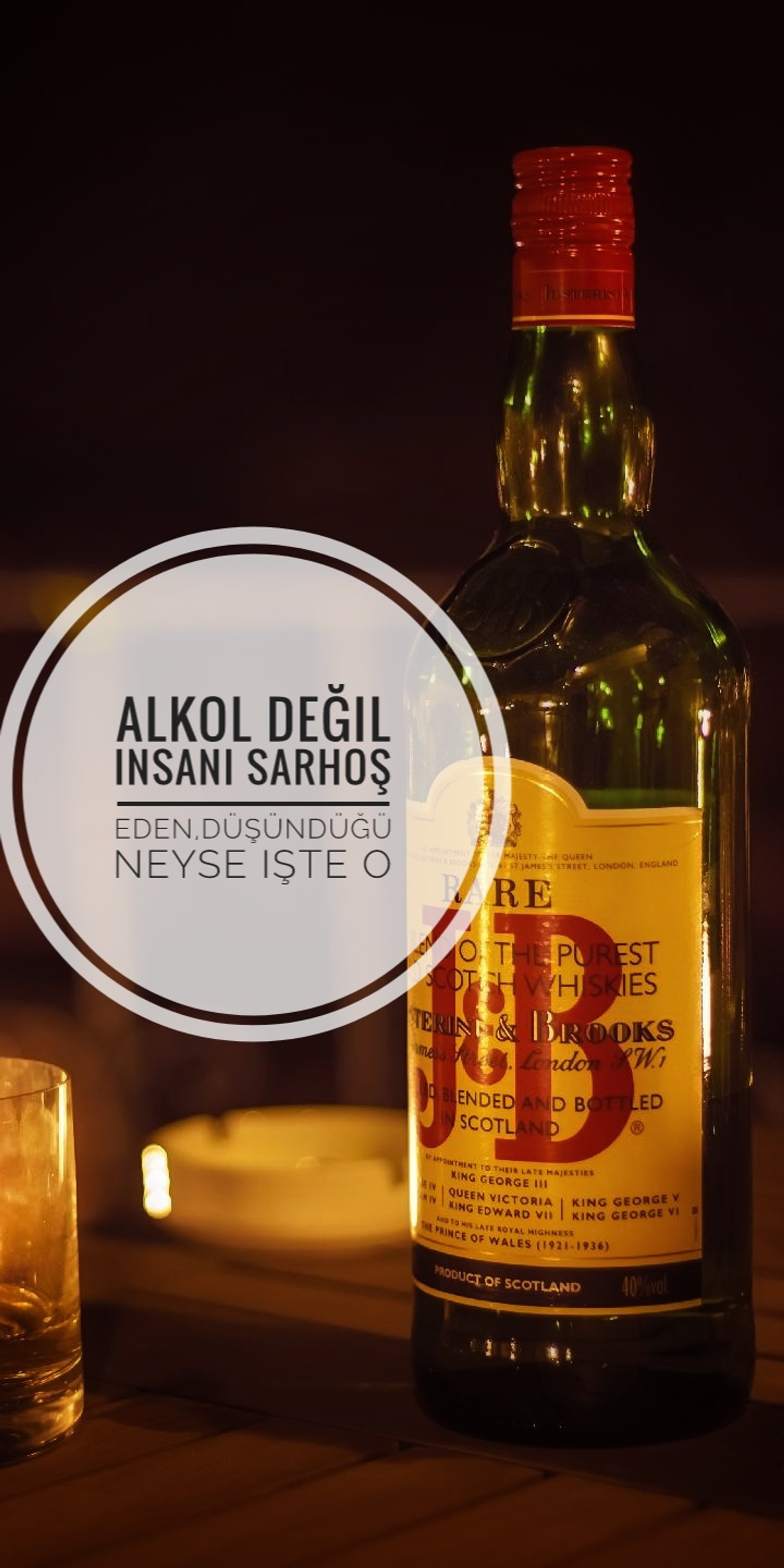 There is a bottle of alcohol sitting next to a glass (alkol, sozler, viski)