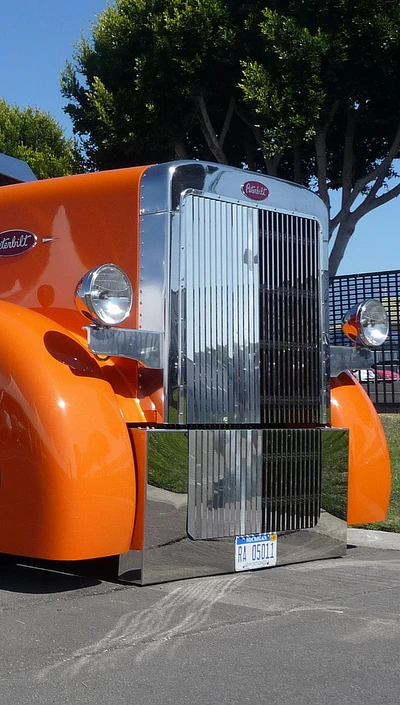 Camion Peterbilt orange classique avec grille chromée