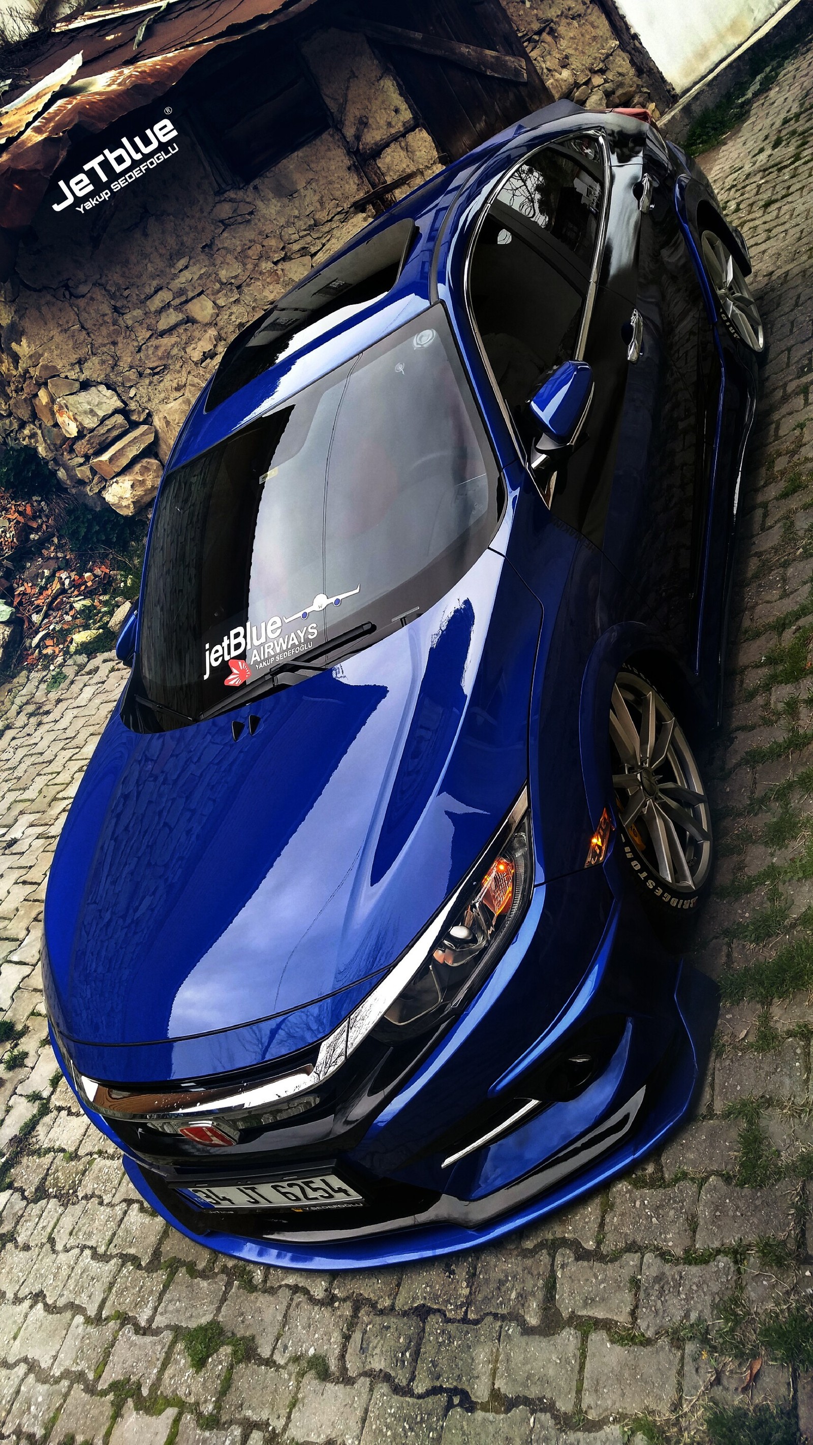 A close up of a blue sports car parked on a brick road (blue, car, cars, civic, honda)