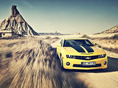 Carro esportivo amarelo correndo ao longo de uma estrada cênica com uma paisagem empoeirada e formações rochosas impressionantes.