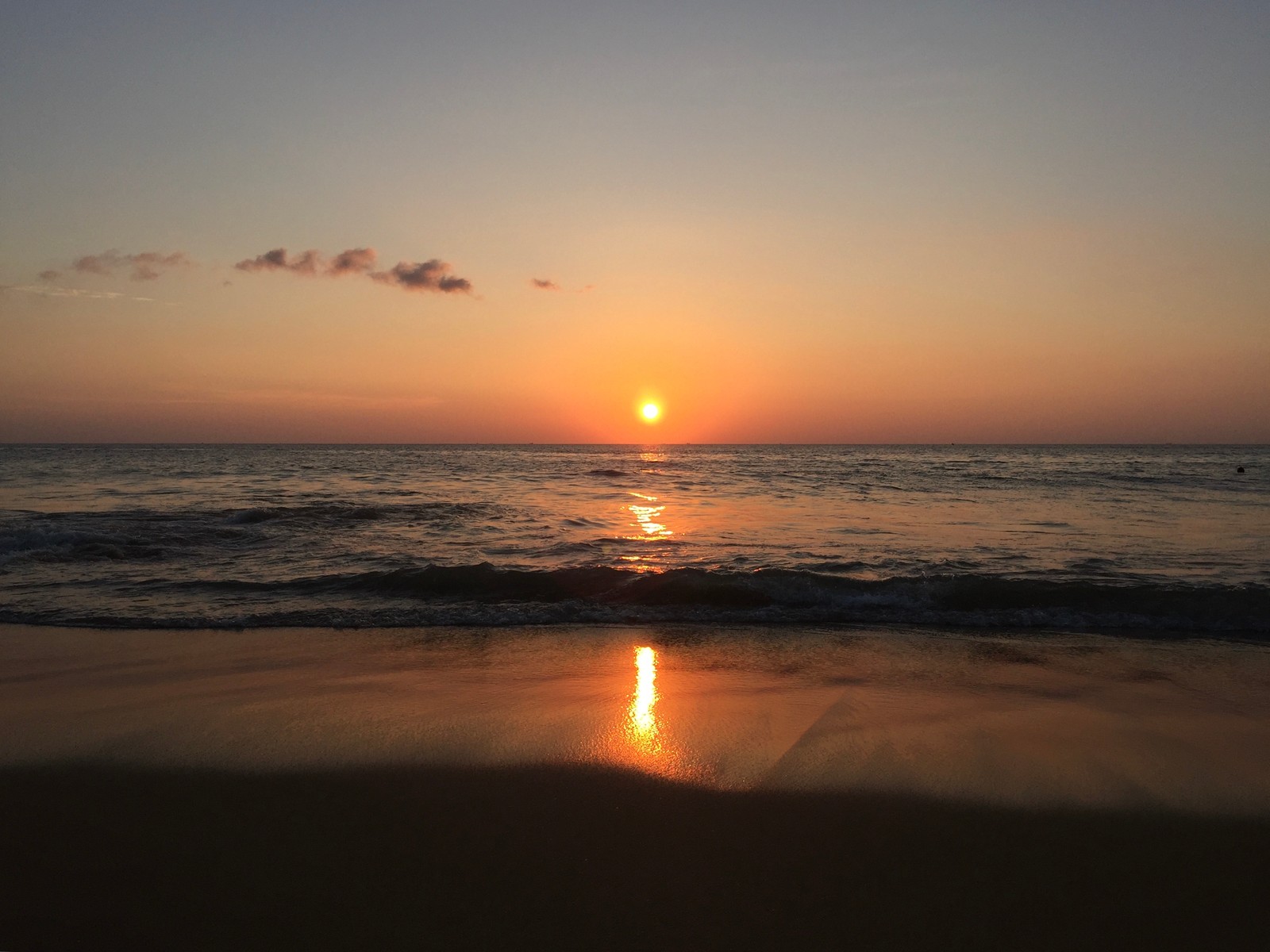 Visão aérea de um pôr do sol sobre o oceano com uma pessoa em uma prancha de surf (atração turística, praia, corpo de água, líquido, natureza)