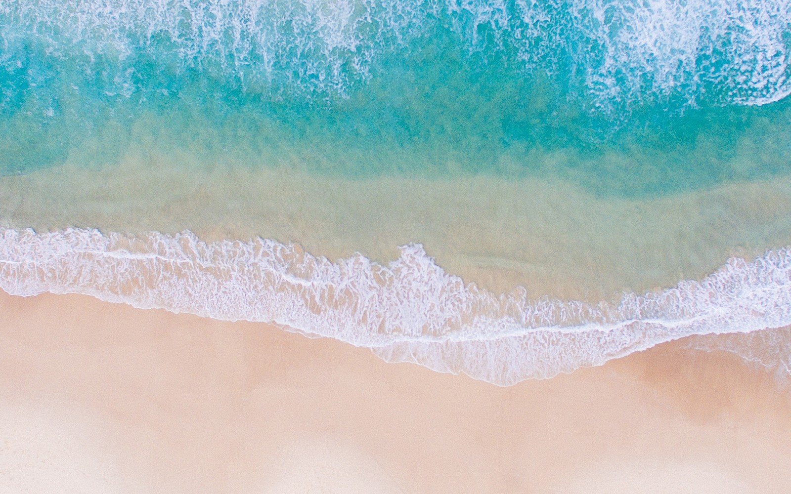 Vue aérienne d'une plage avec une planche de surf et une vague (macbook, macbook air, eau, textile, mer)