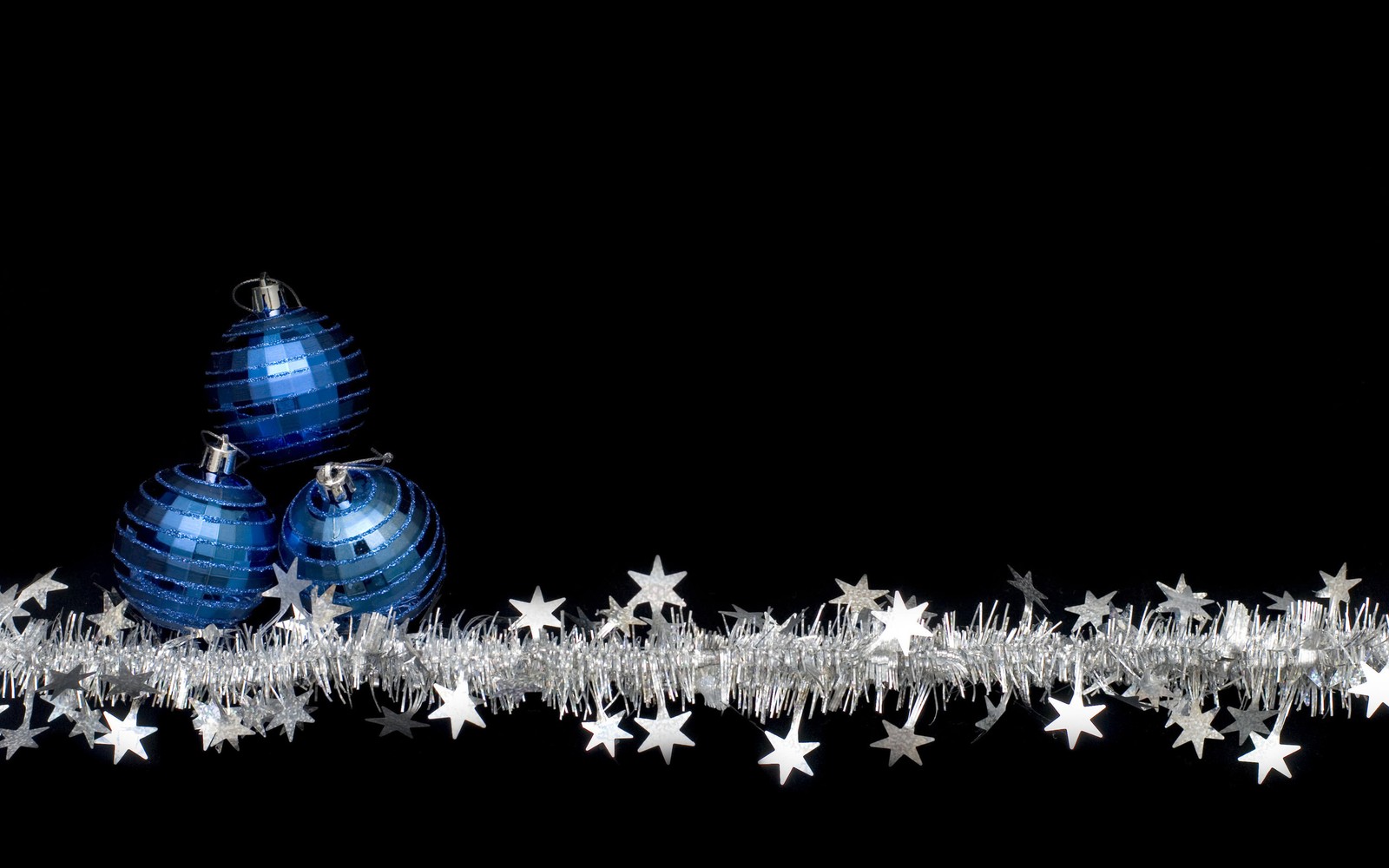 Um close em uma bola de natal azul com estrelas prateadas (dia de natal, ornamento de natal, vistoso, árvore de natal, escuridão)