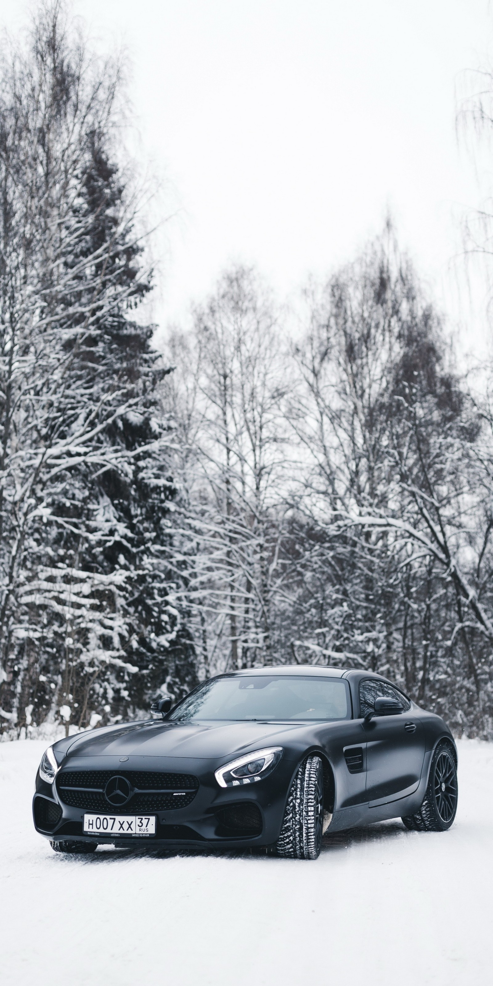 Vue aérienne d'une voiture de sport noire traversant une forêt enneigée (mercedes benz, voitures, voiture de sport, mercedes benz classe c, mercedes benz c class)