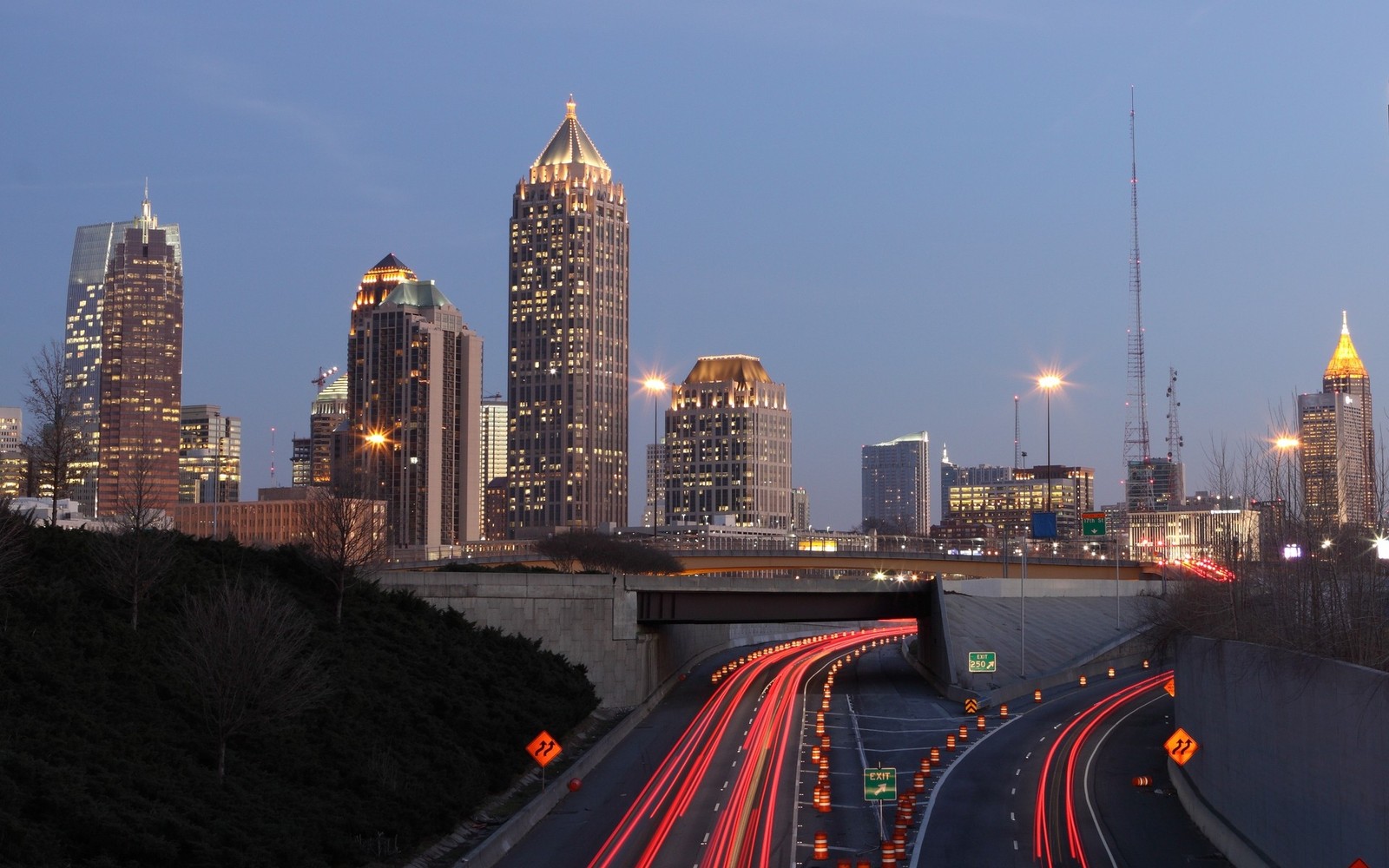 Carros dirigindo em uma rodovia com um horizonte de cidade ao fundo (atlanta, paisagem urbana, cidade, área urbana, arranha céus)