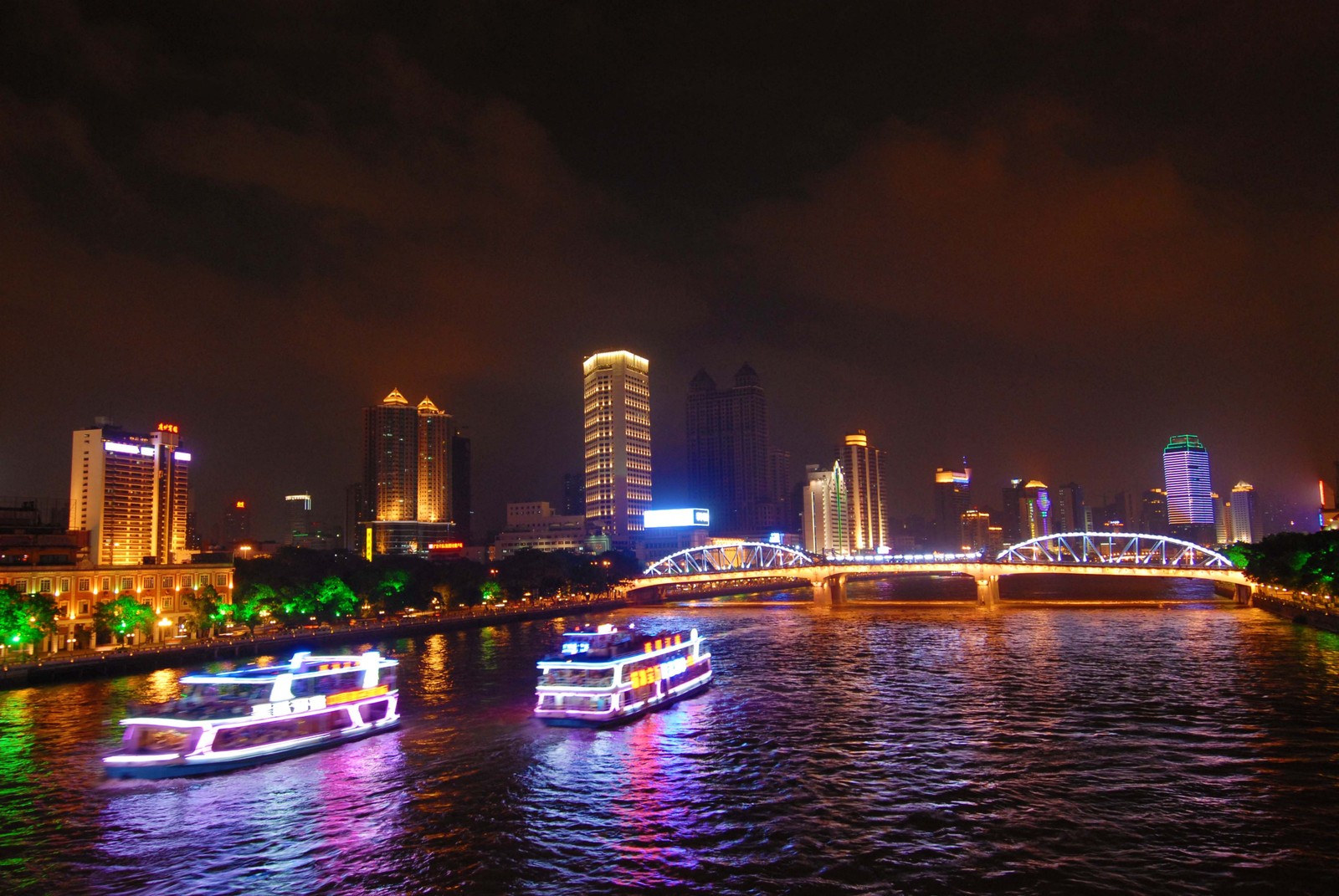 Barcos flutuando na água em uma cidade à noite (paisagem urbana, noite, cidade, metrópole, linha do horizonte)