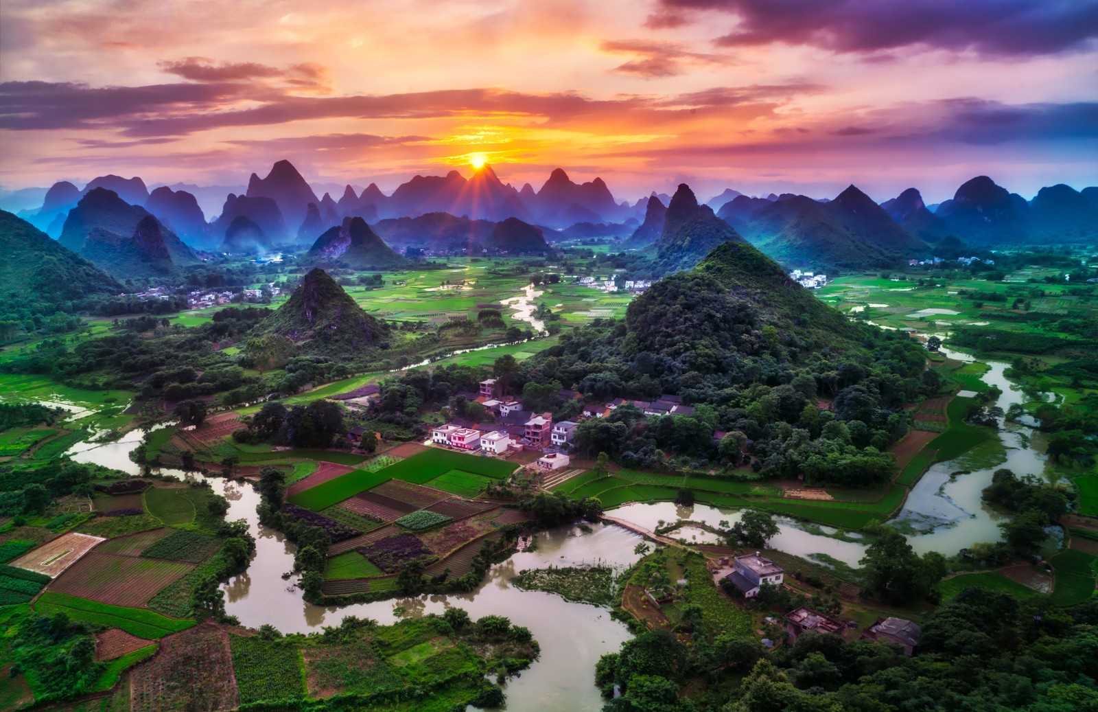 A beautiful sunset over the mountains and rice fields in guizhou county, china (guilin city, china, sunset, beautiful, green fields)