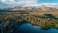 Vista aérea de um sereno lago de montanha cercado por florestas densas