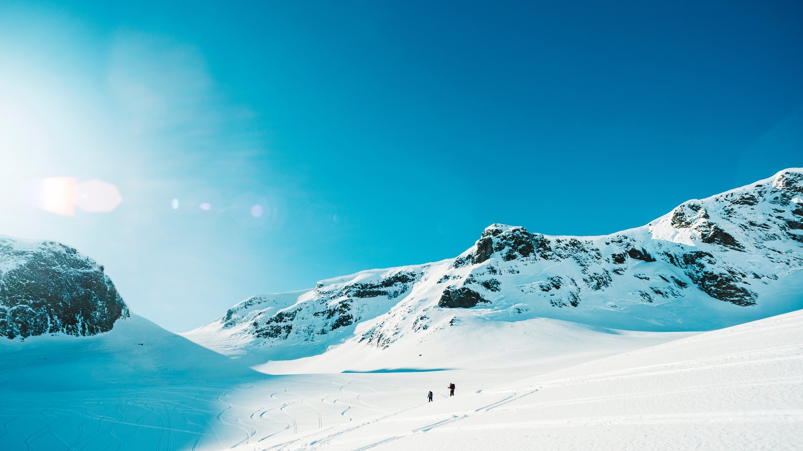 Skiers on a snowy mountain slope with a bright blue sky (snow, ski resort, skiing, mountain, winter)