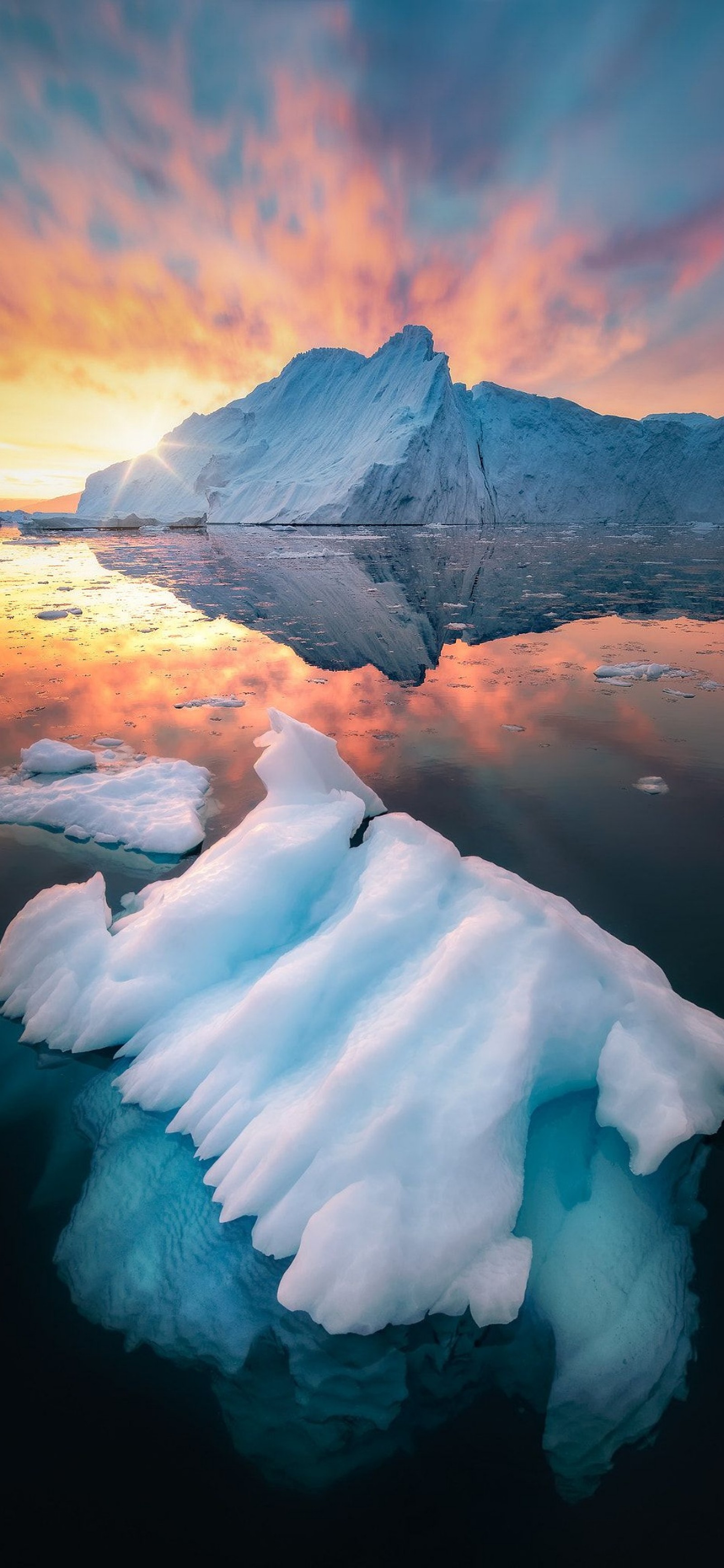 Arafed icebergs floating in the water with a mountain in the background (nature, water, cloud, water resources, atmosphere)