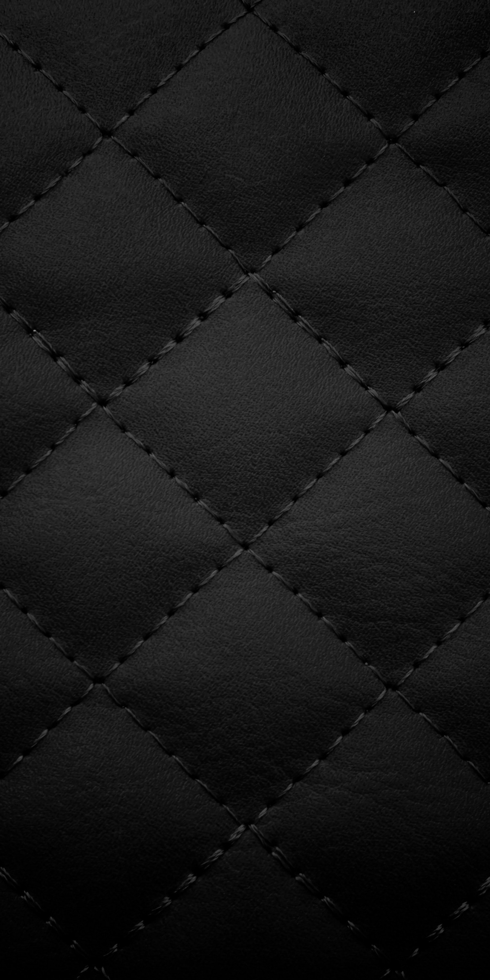 A close up of a black leather texture with a diamond pattern (abstract, black, carpet, space, universe)