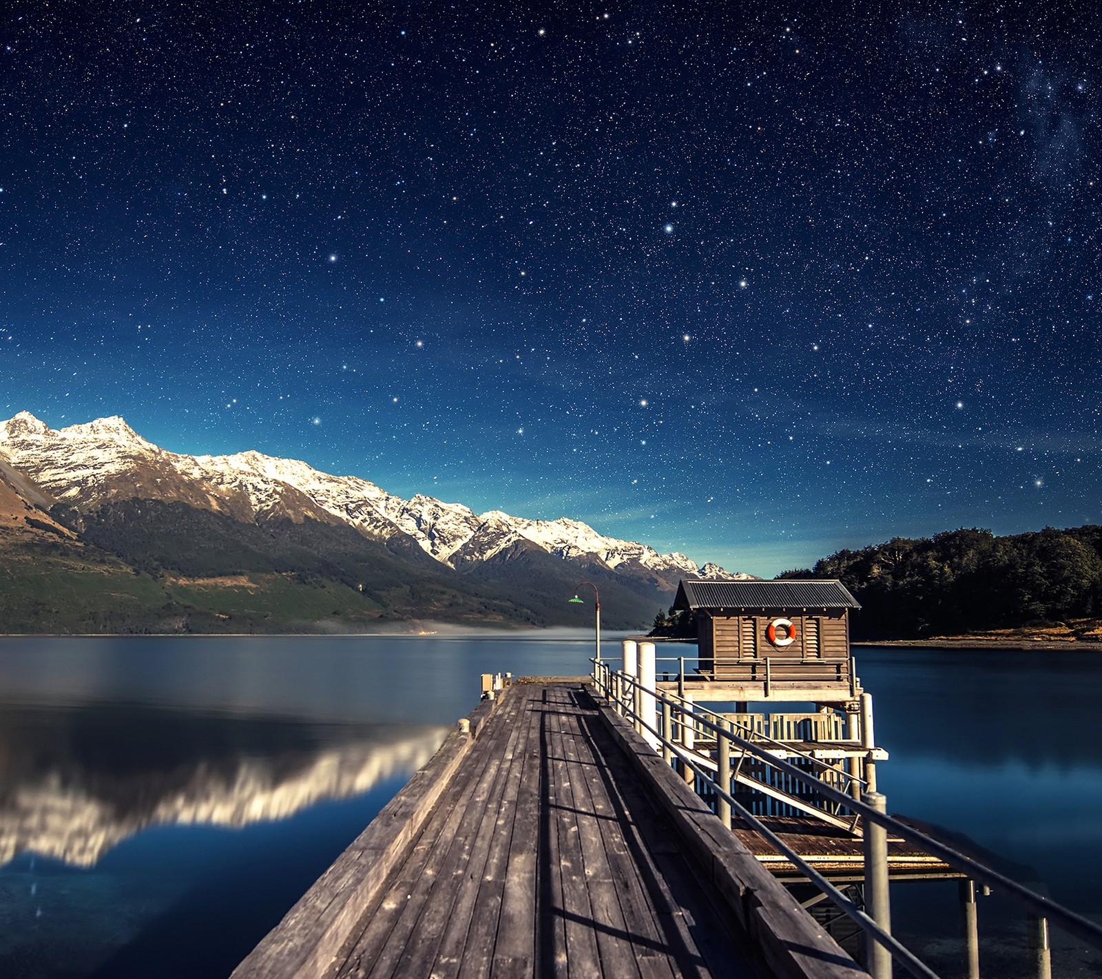 There is a wooden pier with a boat on it and a mountain in the background (awesome, beauty, lake, mountain, nature)