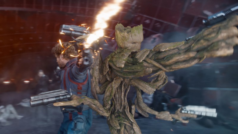 Крупный план мужчины с оружием рядом с деревом (грут, groot, star lord, стражи галактики том 3, guardians of the galaxy vol 3)