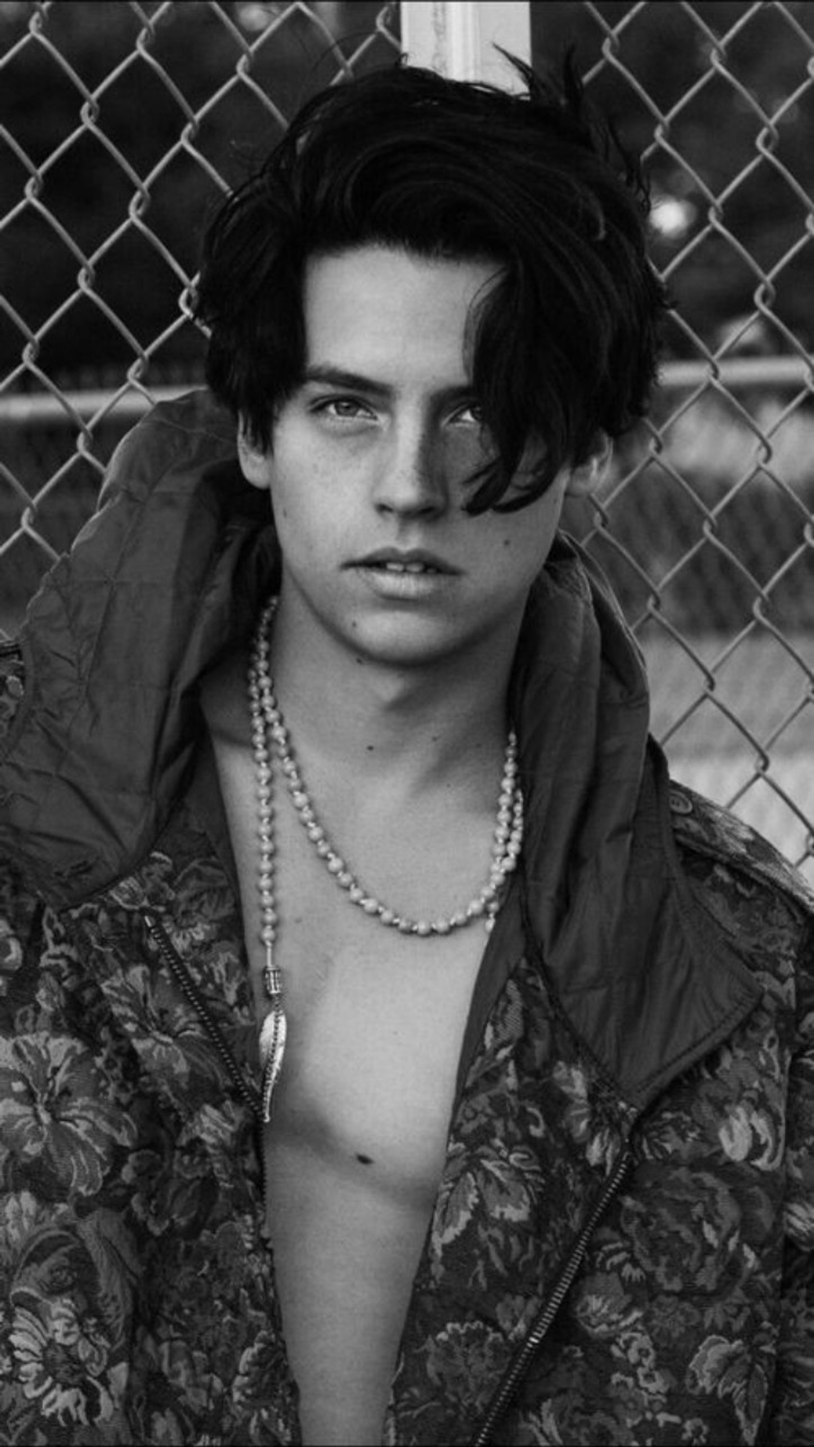 Un primer plano de una persona con una chaqueta y un collar (cole, cole sprouse)