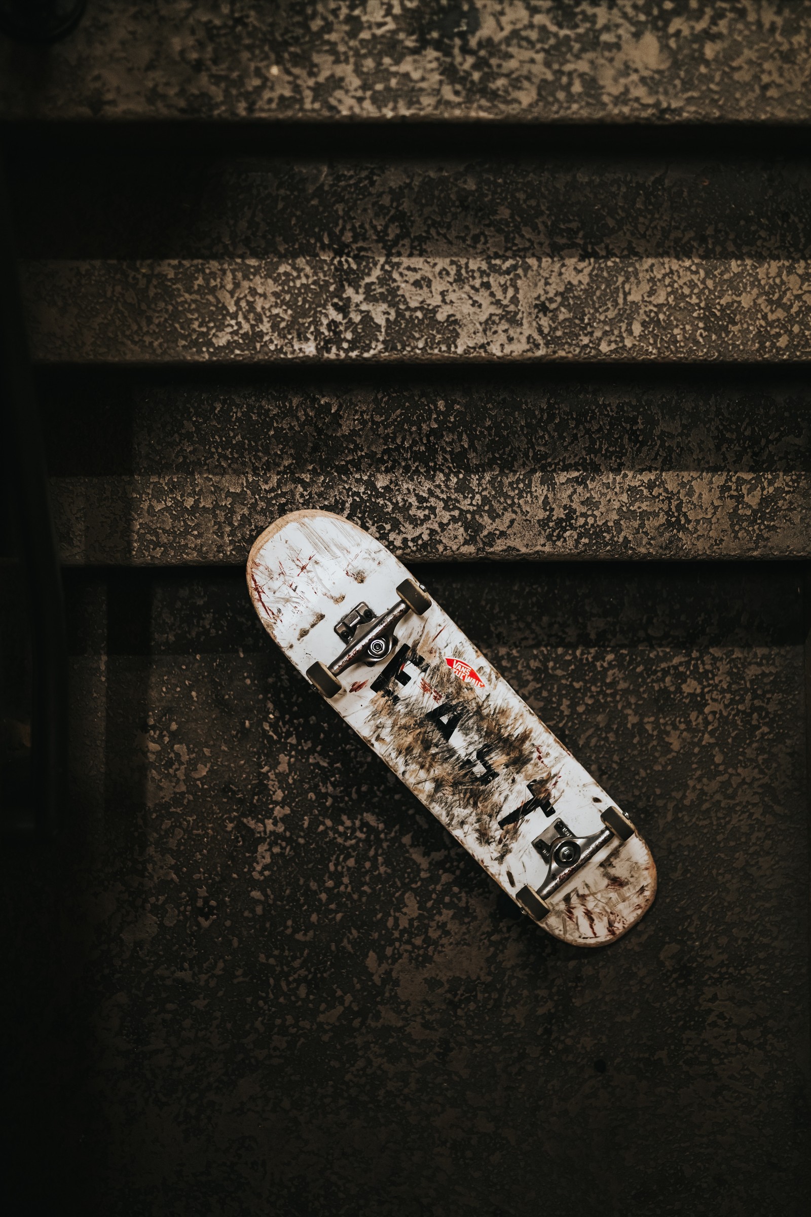 A close up of a skateboard laying on a concrete surface (skateboarding, skateboard, longboarding, longboard, skateboarding trick)