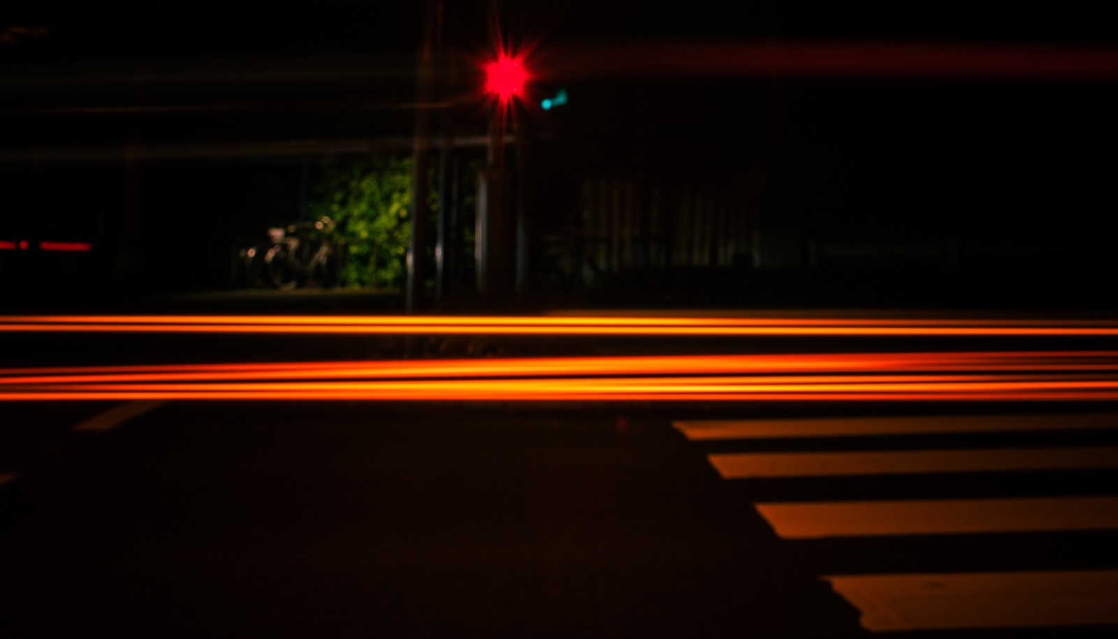 Arafed image of a street at night with a red traffic light (light, line, lighting, night, automotive lighting)