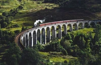 Trem a vapor cruzando a histórica Ponte do Diabo nas Terras Altas da Escócia