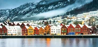 Encantador pueblo de fiordo invernal rodeado de Alpes cubiertos de nieve