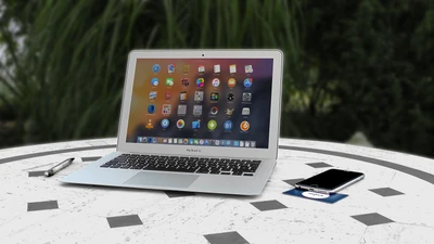 MacBook Air sur une table avec un smartphone et un stylo