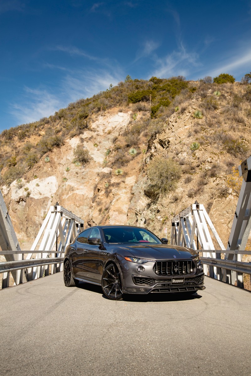 Черный автомобиль, припаркованный на мосту с горой на заднем плане (maserati levante, maserati, машина, кроссовер, audi allroad)