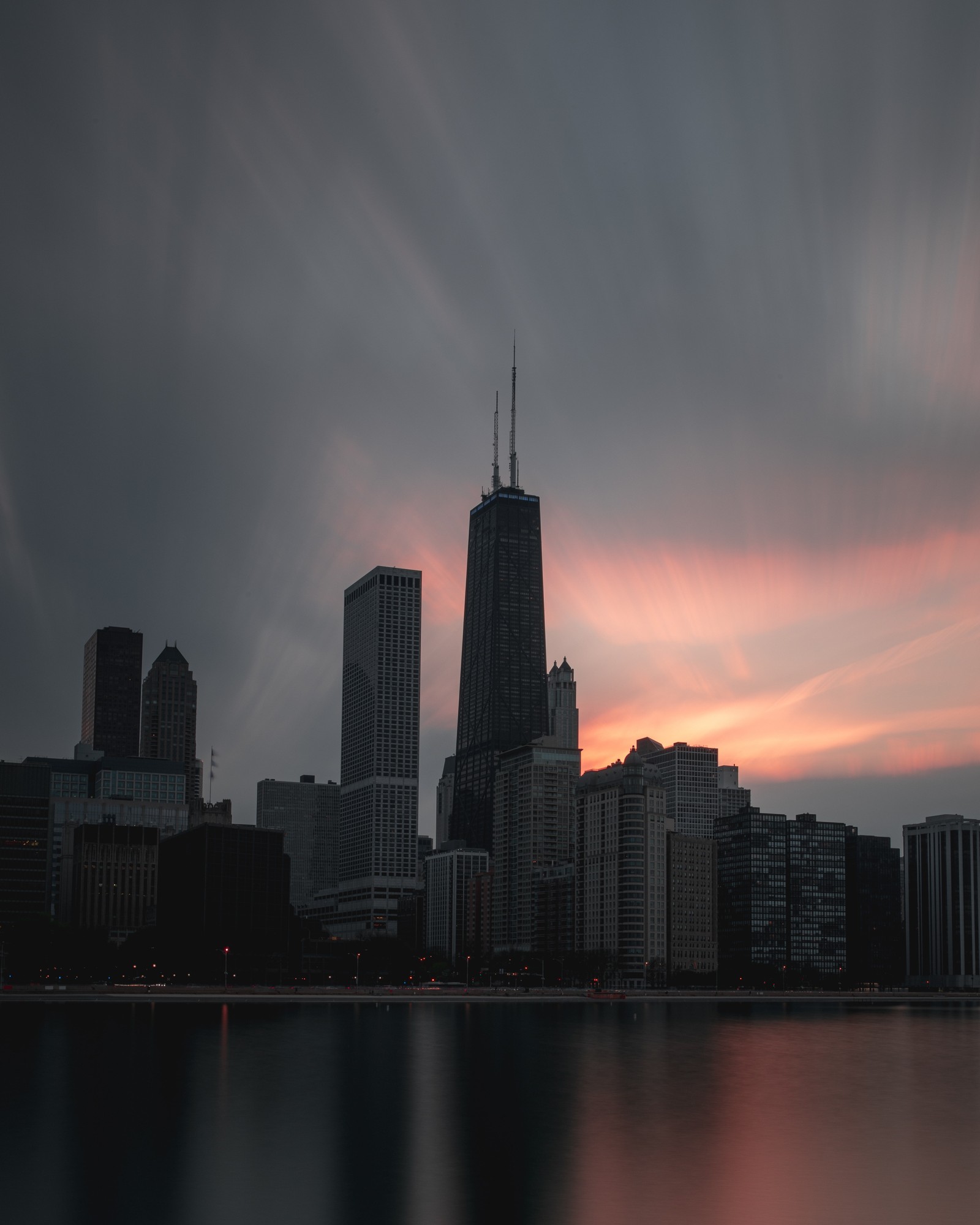 Vista borrada do horizonte de uma cidade com um lago e um pôr do sol. (edifício, por do sol, paisagem urbana, metrópole, chicago)