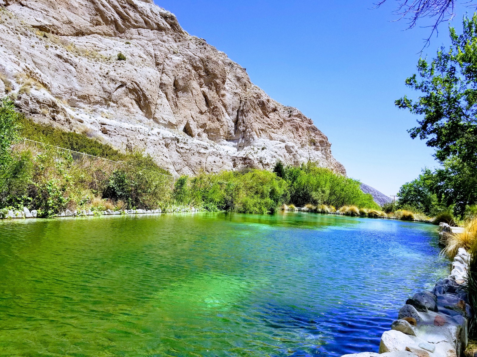 A view of a river with a mountain in the background (lakes, mountains, nature, sky, trees)