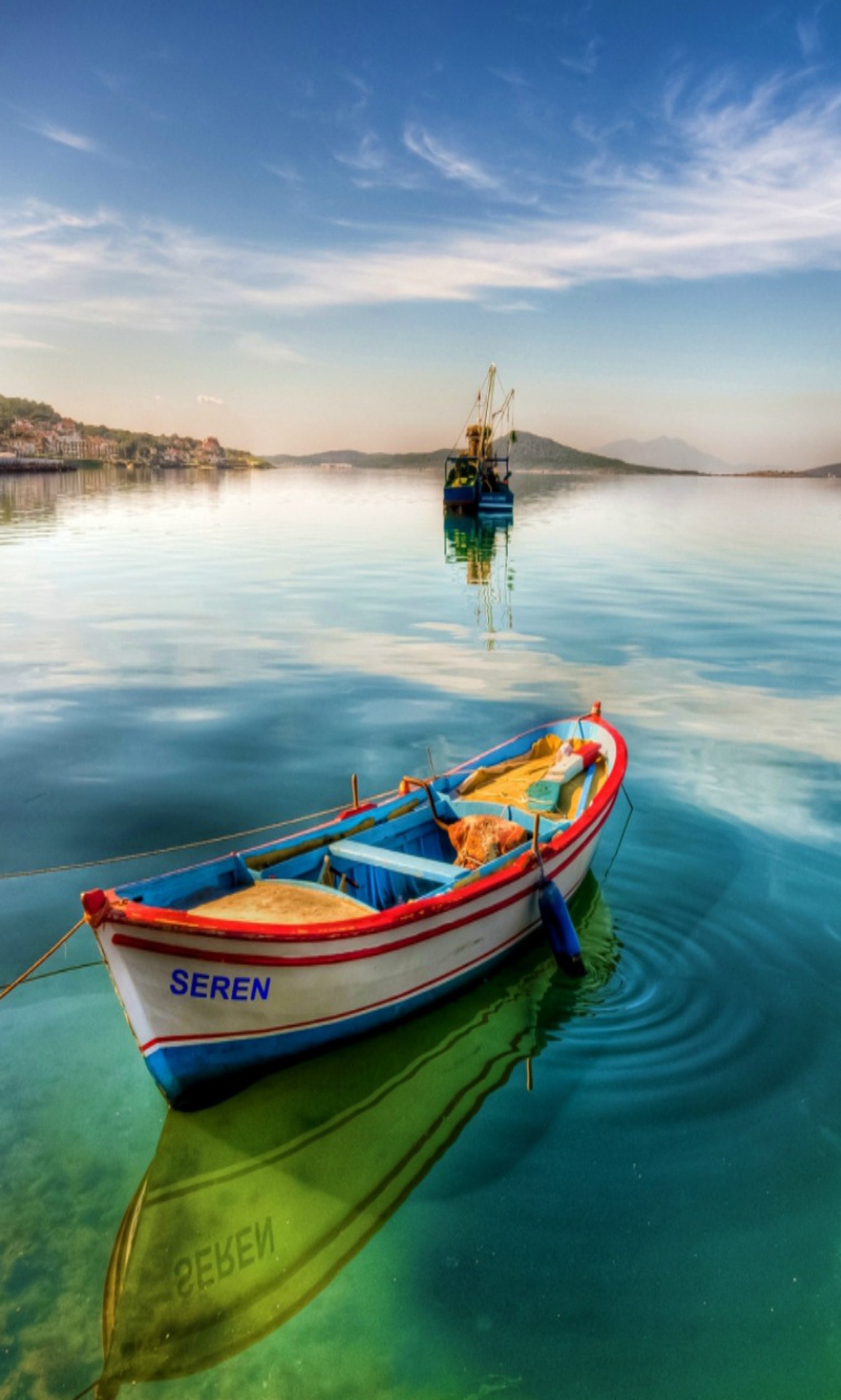 Barcos flutuando na água com um céu azul e algumas nuvens (incrível, legal)