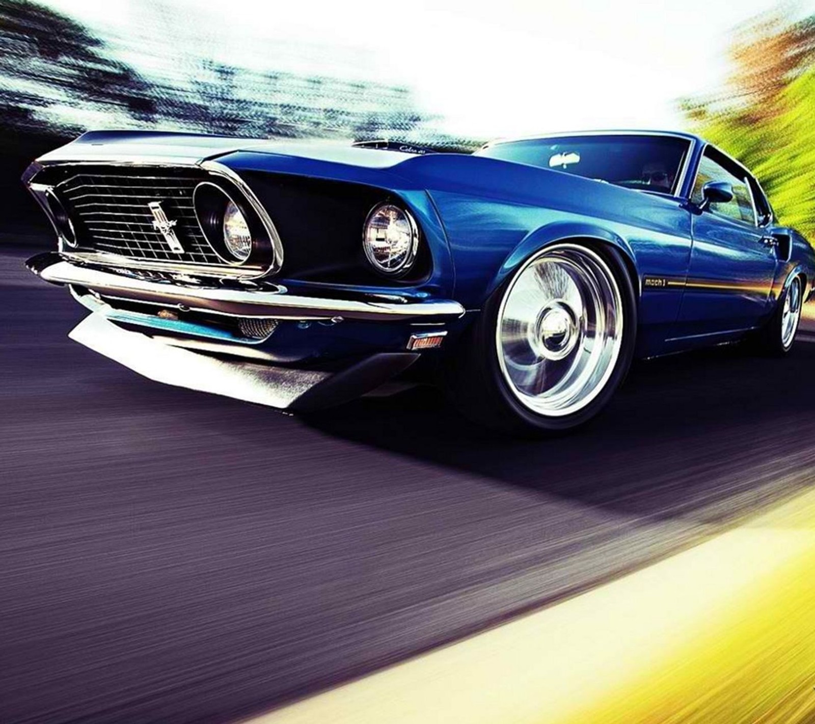 A close up of a blue mustang driving down a road (car, cool, ford, mustang, new)