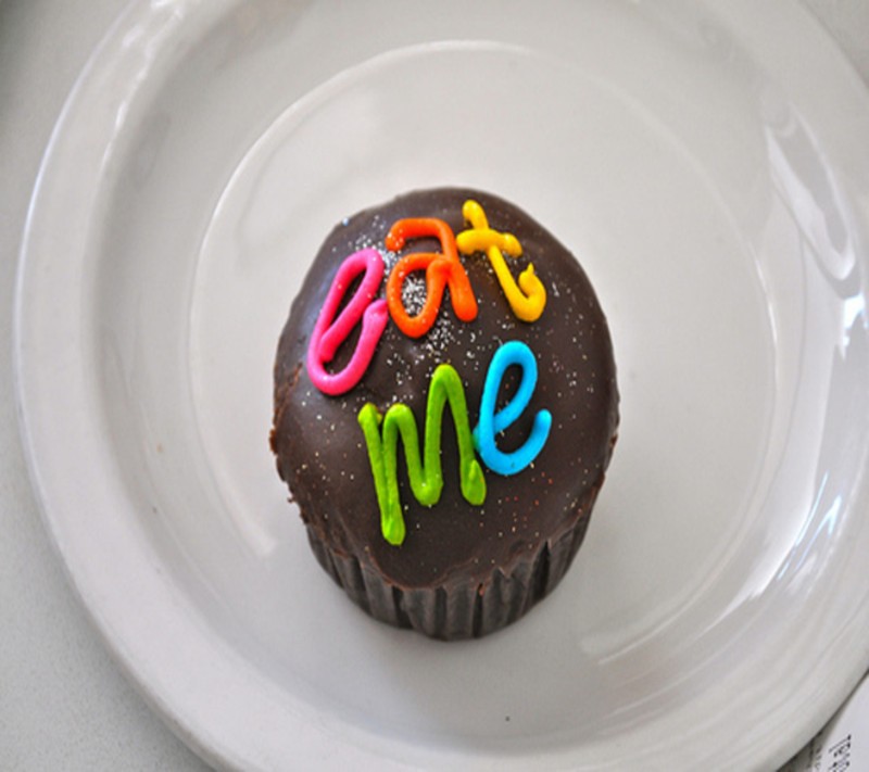 There is a cupcake with the word love spelled on it (cake, cream, cup, cute)