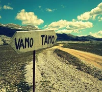 Placa direcional em uma paisagem serena: "Vamo" e "Tamo