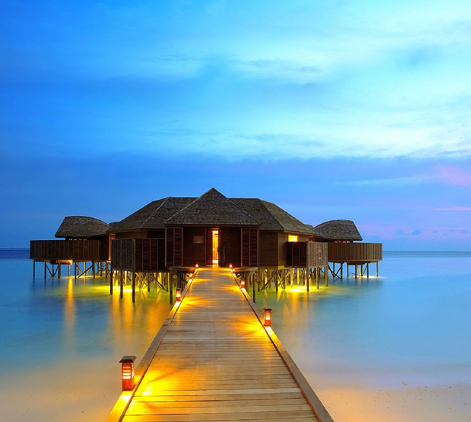 Arafed wooden walkway leading to a beach with a hut on the water (nature)