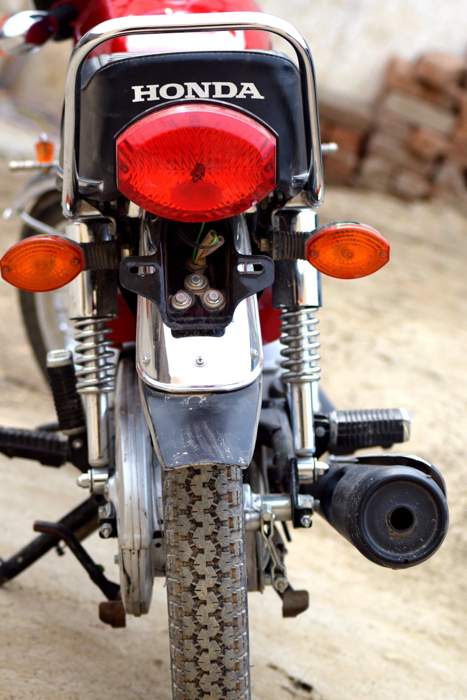 Una motocicleta roja y negra estacionada ao lado de la carretera (honda, honda 125, honda bike)