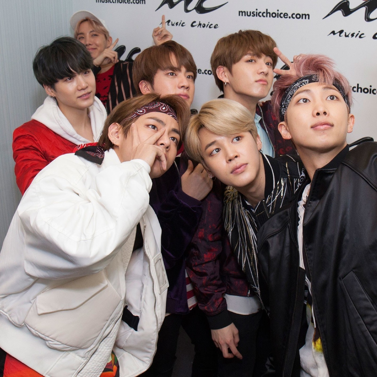 Several young men posing for a picture in front of a wall (bts, members)