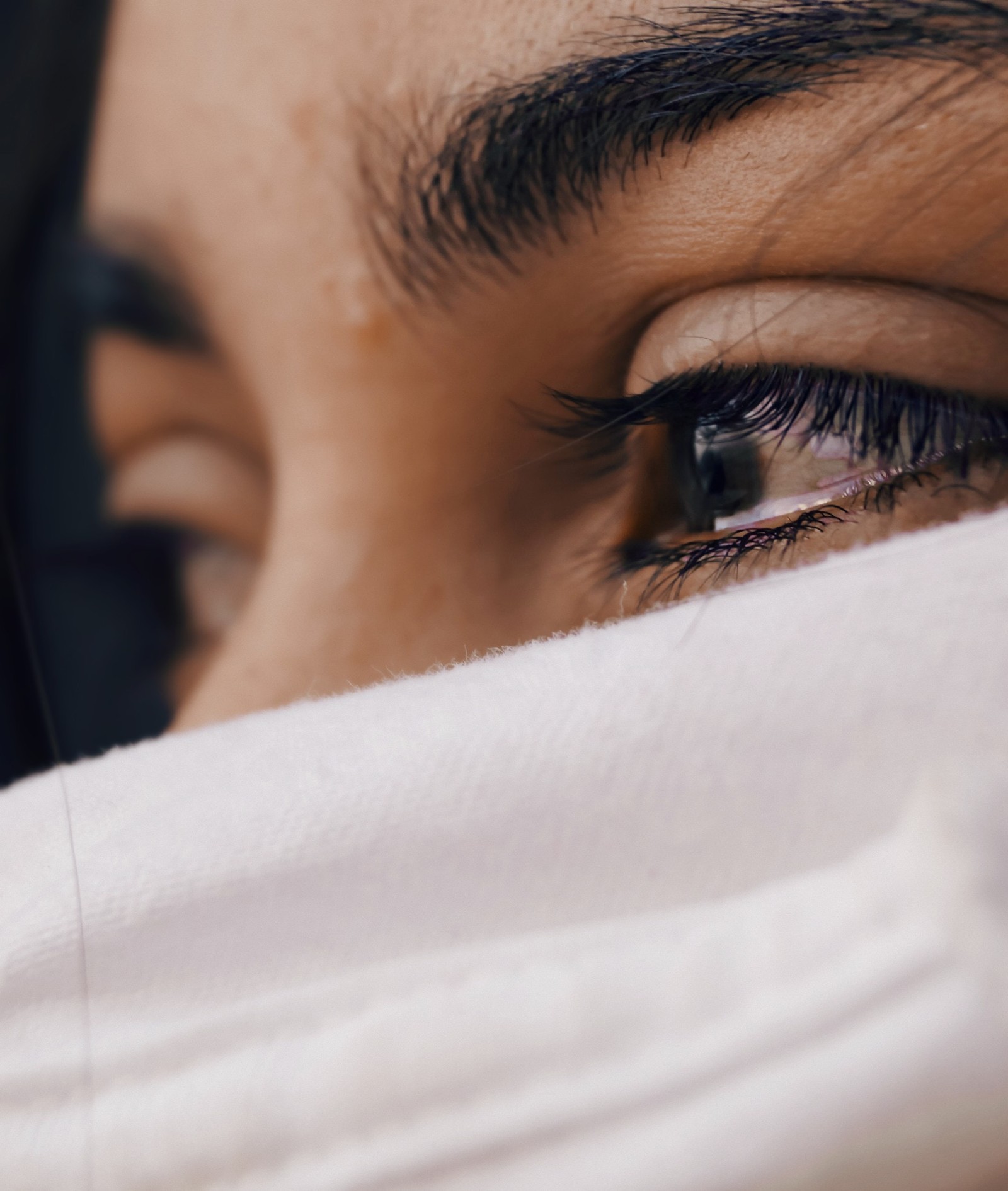 Une femme avec une chemise blanche se couvrant les yeux (pleurer, visage, sourcil, œil, cils)