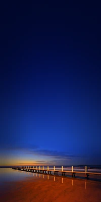 Electric Blue Dusk Over a Tranquil Horizon with a Bridge and Fence