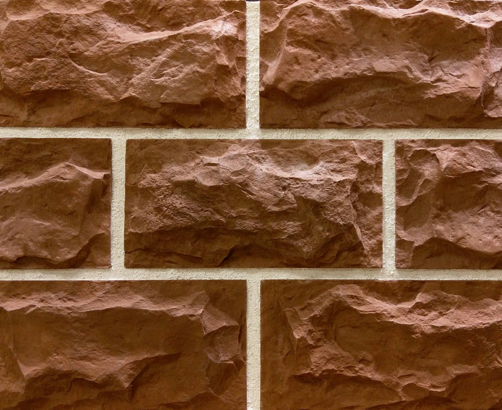 A close up of a brick wall with a red brick (wall, stone wall, brick, artificial stone, stone)