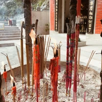 Offrandes d'encens dans un temple traditionnel entouré d'arbres