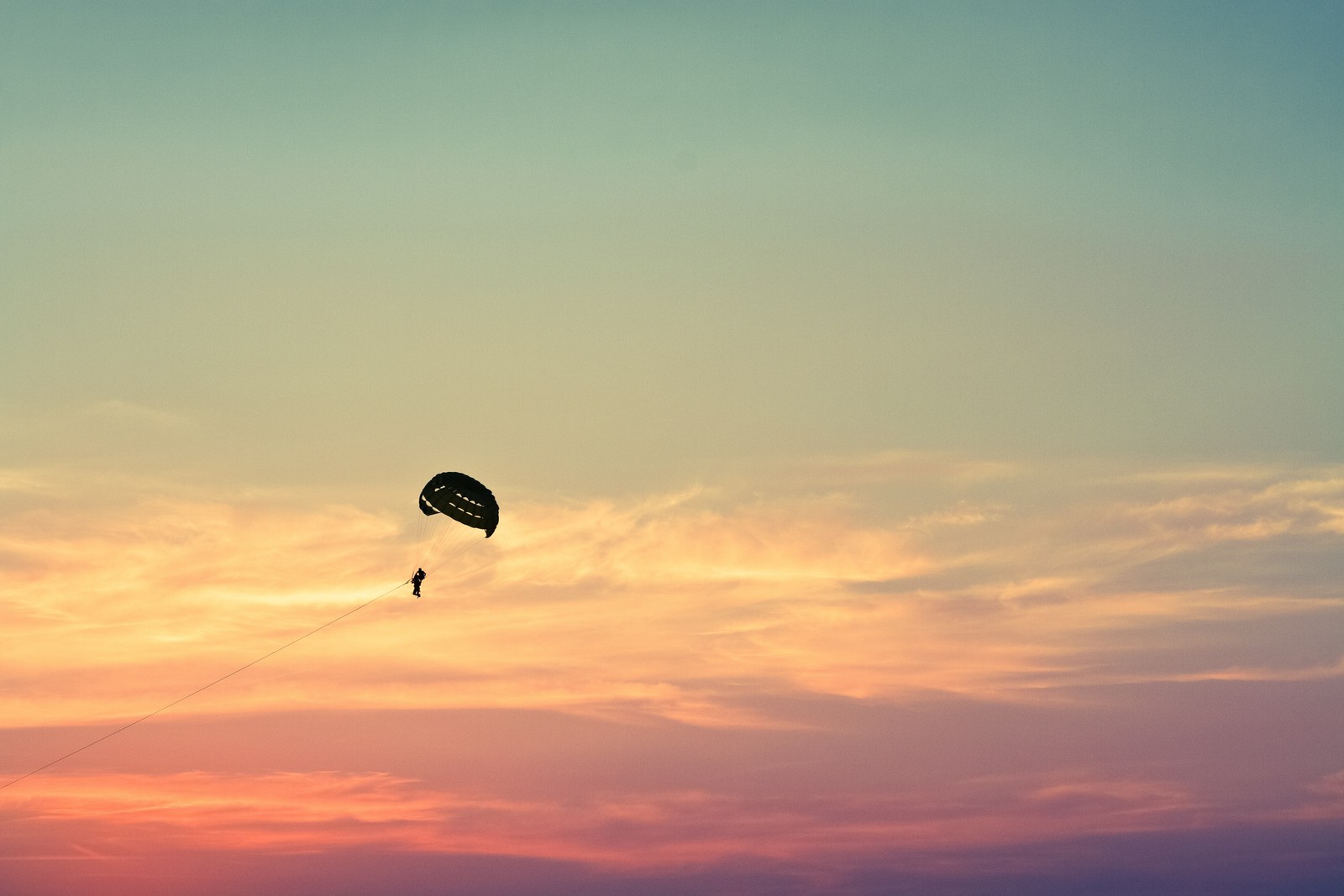 Человек занимается парасейлингом в небе на закате (парасейлинг, parasailing, парашют, парашютный спорт, воздушные виды спорта)