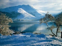 Serenidade de inverno nas Terras Altas da Escócia: montanhas cobertas de neve e um lago glacial