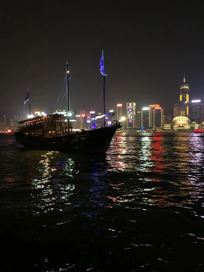 Reflexiones nocturnas de la metrópoli de Hong Kong desde el agua