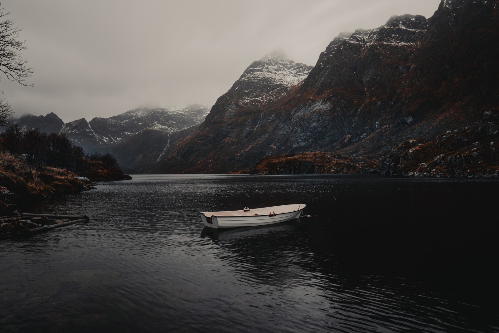 Um pequeno barco que está flutuando na água (terras altas, montanha, fiorde, formas montanhosas, lago)